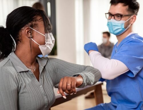 male-nurse-with-mask-greeting-with-patient-in-clin-2024-01-08-20-30-41-utc-min